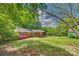 A spacious backyard featuring grass, mature trees, a shed, and a screened porch at 764 Emorywood Ln, Rock Hill, SC 29730