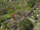 Aerial shot showing a house among the trees, with road access, and lush surrounding greenery. Red arrow indicates subject property at 7790 Caswell Rd, Stanley, NC 28164