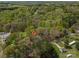 Aerial view of a home surrounded by lush trees and greenery. Red arrow indicates the home for sale at 7790 Caswell Rd, Stanley, NC 28164