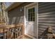 A paneled back door offers access to the home, complemented by wooden rails and exterior siding at 7790 Caswell Rd, Stanley, NC 28164