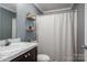 Bathroom featuring single sink, white shower curtain and floating shelves at 7790 Caswell Rd, Stanley, NC 28164