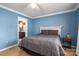 Bedroom with blue walls, carpet and open door to the ensuite bathroom at 7790 Caswell Rd, Stanley, NC 28164