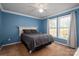 Cozy bedroom with blue walls, carpeted floors, and a ceiling fan at 7790 Caswell Rd, Stanley, NC 28164