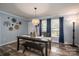 Bright dining area with a dark wood table, bench seating, and modern decor and natural light at 7790 Caswell Rd, Stanley, NC 28164