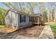 Side view of a cozy single-story home with a charming front porch and well-maintained landscaping at 7790 Caswell Rd, Stanley, NC 28164