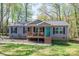 Charming gray home with a wooden porch, a teal front door and beautifully landscaped front yard at 7790 Caswell Rd, Stanley, NC 28164