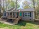 Lovely front exterior showing a cozy home with a wooden porch and nicely landscaped front yard at 7790 Caswell Rd, Stanley, NC 28164
