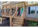 Charming front porch showcasing the home's entry with wooden steps and a cozy sitting area at 7790 Caswell Rd, Stanley, NC 28164