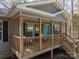 Close-up of the welcoming front porch with a cozy seating area and natural wood finishes at 7790 Caswell Rd, Stanley, NC 28164