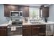 A lovely kitchen features stainless steel appliances, marble countertops, and dark wood cabinets at 7790 Caswell Rd, Stanley, NC 28164