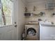 Functional laundry room featuring modern washer, dryer, and ample shelving for storage and supplies at 7790 Caswell Rd, Stanley, NC 28164