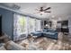 Open-concept living room with large windows, stylish furniture, and seamless flow to the kitchen area at 7790 Caswell Rd, Stanley, NC 28164