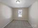 Empty bedroom featuring neutral decor, plush carpeting, a large window, and natural light at 808 Raindrops Rd, Gastonia, NC 28054