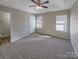 Main bedroom featuring a trey ceiling, ceiling fan, carpet flooring, and two windows with blinds at 808 Raindrops Rd, Gastonia, NC 28054