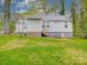 Backyard showcasing the home's exterior with a small deck, lawn and mature trees at 809 N Ransom St, Gastonia, NC 28052