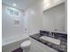 Well-lit bathroom features a shower-tub and sink with marbled countertop at 809 N Ransom St, Gastonia, NC 28052