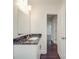 Bathroom vanity features dark marbled countertop, mirror, and wood-style flooring at 809 N Ransom St, Gastonia, NC 28052