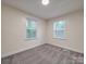 Bedroom has carpet and view of backyard with two windows letting in lots of natural light at 809 N Ransom St, Gastonia, NC 28052