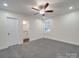 Bright bedroom featuring neutral walls, plush gray carpet, and a ceiling fan for enhanced comfort at 809 N Ransom St, Gastonia, NC 28052
