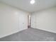 Neutral bedroom with carpet, white walls, and two doors for access and storage at 809 N Ransom St, Gastonia, NC 28052