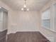 Dining room with hardwood floors and modern chandelier lighting; one bright window bringing in natural light at 809 N Ransom St, Gastonia, NC 28052