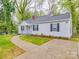 Exterior view of a home with nice landscaping, a gray roof, black shutters and stamped concrete driveway at 809 N Ransom St, Gastonia, NC 28052