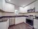 Modern kitchen features white cabinets, stainless steel appliances, and dark marbled countertops at 809 N Ransom St, Gastonia, NC 28052