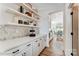 Bright hallway featuring stylish shelving, white cabinets, modern hardware, and access to the kitchen and dining area at 8618 Frank Grier Rd # 58, Charlotte, NC 28215