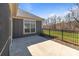 Backyard patio and a grassy area with an iron fence and wooded views beyond at 9087 Treetop Nw Way, Concord, NC 28027