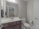 This half-bath includes a white vanity, a dark wood cabinet, and a toilet at 9087 Treetop Nw Way, Concord, NC 28027