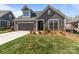 Exterior view of the home with a dark brown garage, a dormer window, and well-maintained landscaping at 9087 Treetop Nw Way, Concord, NC 28027