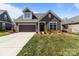 Exterior view of the home with a dark brown garage, a dormer window, and well-maintained landscaping at 9087 Treetop Nw Way, Concord, NC 28027