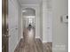 Inviting hallway with hardwood floors leads to an arched entry to the dining area at 9087 Treetop Nw Way, Concord, NC 28027