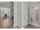Hallway showcasing wood floors and access to a full bathroom, dining area, and living area at 9087 Treetop Nw Way, Concord, NC 28027