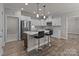 Kitchen featuring white cabinetry, an island with bar stools, and stainless steel appliances at 9087 Treetop Nw Way, Concord, NC 28027