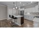 Kitchen with stainless steel appliances, a large island, and white cabinets at 9087 Treetop Nw Way, Concord, NC 28027