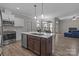 Open kitchen with an island featuring a sink, and a stainless steel dishwasher at 9087 Treetop Nw Way, Concord, NC 28027