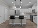 Open kitchen with island seating, stainless appliances and white cabinetry at 9087 Treetop Nw Way, Concord, NC 28027