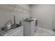 This laundry room includes a utility sink, shelving and a washer and dryer at 9087 Treetop Nw Way, Concord, NC 28027