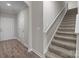 Hallway featuring wood-look floors, neutral walls, and a carpeted staircase with a white handrail at 9087 Treetop Nw Way, Concord, NC 28027