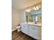 Stylish bathroom showcasing a double vanity, large mirror, and wood-look flooring at 9419 Seamill Rd, Charlotte, NC 28278