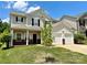 Welcoming two-story home with a front porch, two-car garage, and green lawn on a sunny day at 9419 Seamill Rd, Charlotte, NC 28278