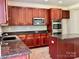 Kitchen featuring granite countertops, stainless steel appliances, wooden cabinets, and a center island at 9419 Seamill Rd, Charlotte, NC 28278