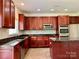 Well-equipped kitchen showcases wooden cabinets, stainless steel appliances, granite counters, and a center island at 9419 Seamill Rd, Charlotte, NC 28278