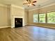 Bright living room showcases a fireplace, hardwood floors, and large windows overlooking the backyard at 9419 Seamill Rd, Charlotte, NC 28278
