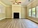 Cozy living room highlights a fireplace, hardwood floors, and ample natural light through the windows at 9419 Seamill Rd, Charlotte, NC 28278