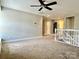Spacious loft area featuring plush carpeting, neutral colors, and a ceiling fan at 9419 Seamill Rd, Charlotte, NC 28278