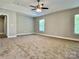 This primary bedroom features a trey ceiling, fan, and bright windows at 9419 Seamill Rd, Charlotte, NC 28278