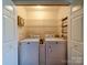 Bright laundry room with a washer, dryer, shelving, and ample storage space behind white doors at 9539 Errington Ln, Mint Hill, NC 28227