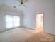 Main bedroom with carpet, large windows, and a walk-in closet at 9539 Errington Ln, Mint Hill, NC 28227